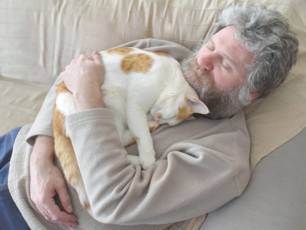 Owner comforting senior cat on hospice care